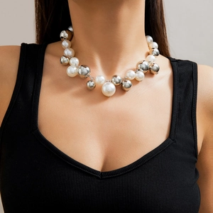 Detailweergave van grote witte parels en zilveren metalen bollen op een korte choker