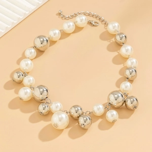 Detail van grove parel choker ketting met zilveren metalen ballen en een kreeftsluiting