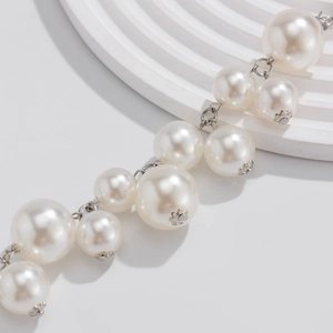 Macro-opname van grote imitatieparels met elegante zilveren metalen kapjes op een choker