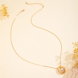 Detail of minimalist gold teardrop pendant on a sleek snake chain with lobster clasp