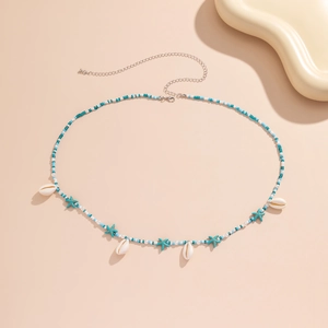 Détail de chaîne de corps bohème avec étoiles de mer turquoise et pendentifs coquillages