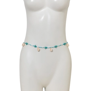 Détail de chaîne de taille plage avec pendentifs étoile de mer, perles blanches et coquillages