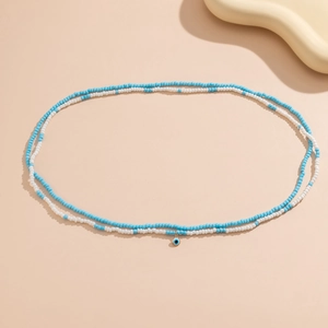 Détail de la chaîne de taille bohème avec perles bleues et pendentif œil maléfique