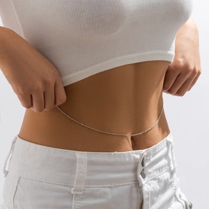 Close-up of minimalist silver metal waist chain on model with sleek geometric link detail