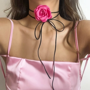 Close-up of pink satin rose choker necklace with long black velvet ribbon on model