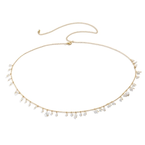 Detail of gold chain body jewelry with white faux pearls and star-shaped charms