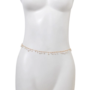 Detail of gold metal body chain featuring faux pearls and star charms on a white mannequin