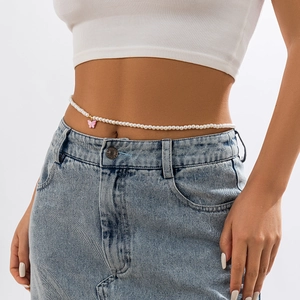 Close-up of pearl waist chain with pink butterfly pendant on denim skirt