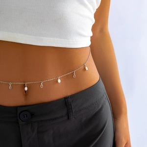 Close-up of silver metal waist chain with alternating white pearls and drop pendants