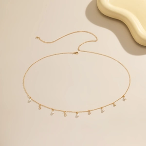 Detail of golden chain body jewelry with pearl tassels and teardrop pendants