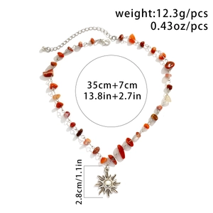 Detail of bohemian necklace with colorful gravel beads and silver sun charm pendant