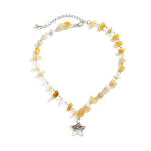 Detail view of irregular yellow stone necklace with hollow star and tree of life pendant