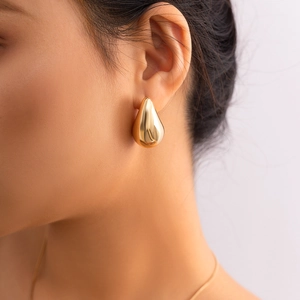 Minimalist gold teardrop earrings for women featuring a mirror polished finish on model