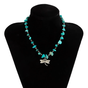 Detail of turquoise gravel necklace with a silver dragonfly pendant on a black bust