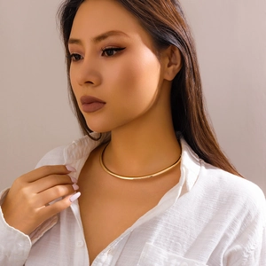 Minimalist polished gold metal collar necklace for women shown on model in white shirt