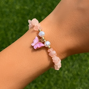 Dettaglio della collana di perline con pietre rosa, perle e ciondolo a farfalla