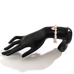 Dettaglio del bracciale in cristallo rosa con perle bianche e ciondolo a farfalla