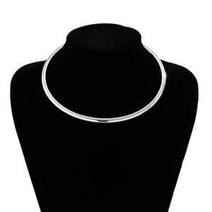 Close-up of minimalist polished silver choker necklace on black velvet display