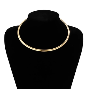 Close-up of minimalist gold-plated metal choker necklace on a black velvet neck bust
