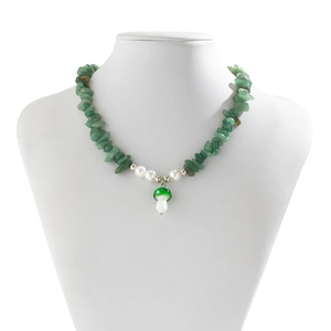 Detail of stone necklace with green gravel, white pearls and a cute mushroom pendant