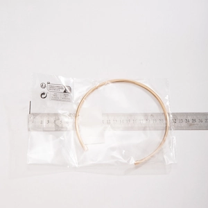 Detail view showing a minimalist rose gold choker collar being measured at 13cm diameter