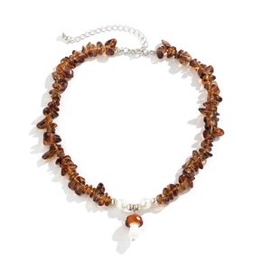 Close-up of brown irregular stone necklace with pearl accents and mushroom pendant