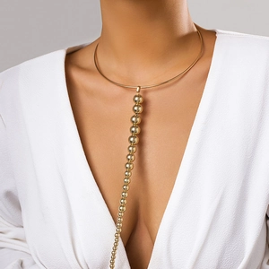 Makro-Detail des polierten goldenen Chokers mit langem Perlenanhänger am Model