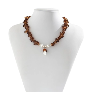 Detail of amber gravel necklace with white pearls and a red-brown mushroom pendant