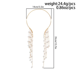 Detailed view of long gold tassels and white pearls on a minimalist choker necklace