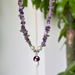 Detail of amethyst gravel necklace with white pearls and a purple mushroom pendant