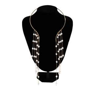 Detailed view of a gold choker with long tassel chains and faux pearl embellishments