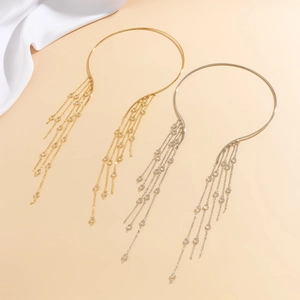 Detailed close-up of metallic choker necklace with dangling tassel and crystal charms