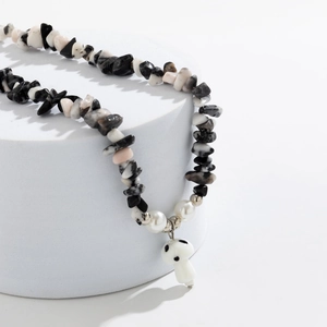 Macro shot of irregular gravel stone necklace with white mushroom pendant and pearls