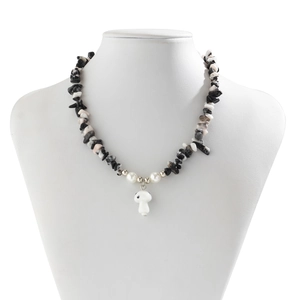 Detail of beaded necklace with irregular crushed stones, pearls and white mushroom charm