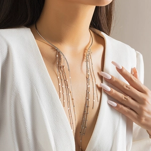 Detail of silver choker necklace featuring long metallic tassels and sequin accents