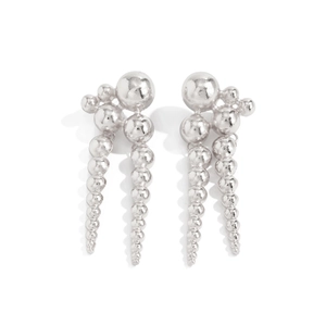 Détail de boucles d'oreilles punk argentées avec sphères métalliques et glands