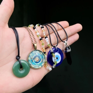 Λεπτομέρεια από τέσσερα boho κολιέ με το μάτι, μαντάλα και εξαγωνικό κρύσταλλο μενταγιόν
