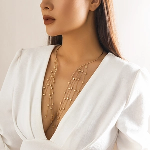 Detail of gold choker with cascading star fringe tassels on white V-neck background