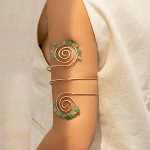 Λεπτομερής λήψη έθνικ χρυσού περιβραχιόνιου με πράσινες φυσικές πέτρες και σύρμα