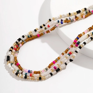 Detailopname van gelaagde veelkleurige glaskraaltjes voor zomerse strand tailleketting