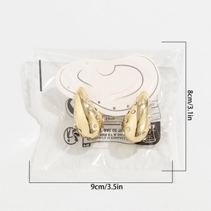 Detailed view of golden teardrop earrings with rhinestones in 8x9cm packaging