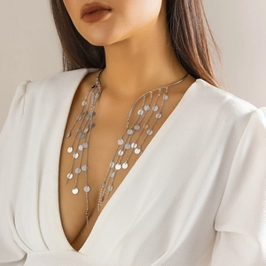 Macro detail of silver long tassel choker featuring polished metal sequins and pearls