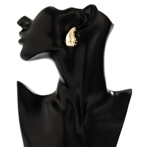 Macro detail of gold teardrop earring with inlaid crystals on mannequin model