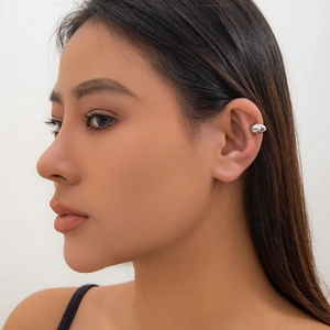 Close-up of a high-polished silver ear cuff on a female model with a sleek teardrop design