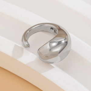 Macro shot of silver teardrop earrings with a high-polished mirror finish on a pedestal