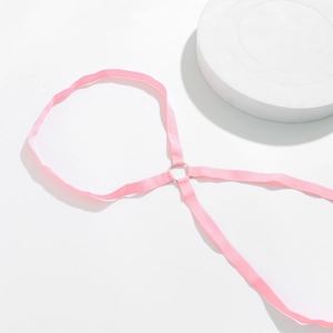 Detail van roze elastische beenketting met een zilveren metalen ring op witte display