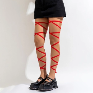 Detail of red satin lace-up leg harness wrap with crossover ribbons and black skirt
