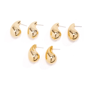 Detailed view of polished gold teardrop earrings set with high gloss mirror finish