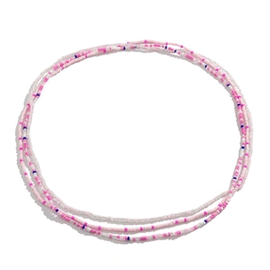 Detail van een vierlaagse roze en witte kralen tailleketting voor een strandlook