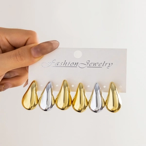 Detailed set of six gold and silver teardrop earrings on a white jewelry display card